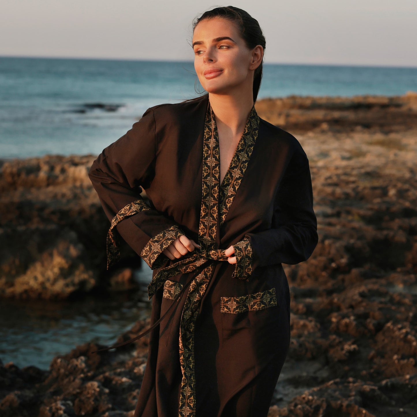 Vrouw in zwarte kimono op het strand